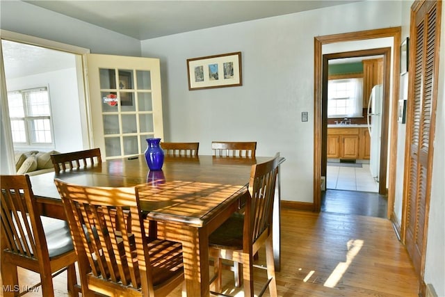 dining room featuring sink and light hardwood / wood-style floors