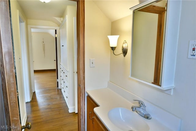 bathroom featuring vanity, hardwood / wood-style flooring, and lofted ceiling