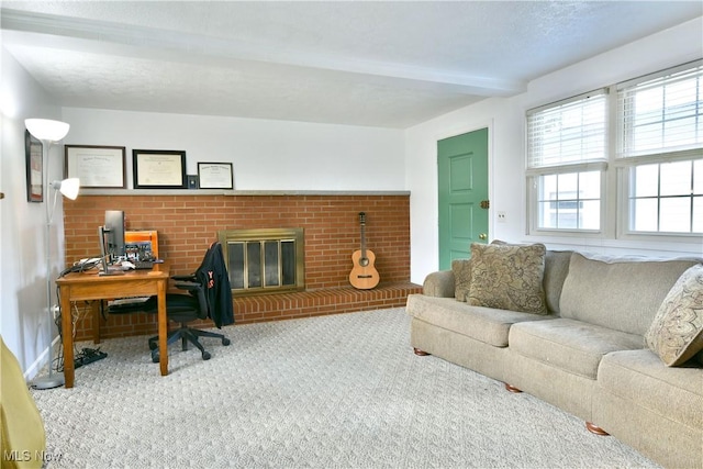 office area with a brick fireplace, beam ceiling, and carpet flooring