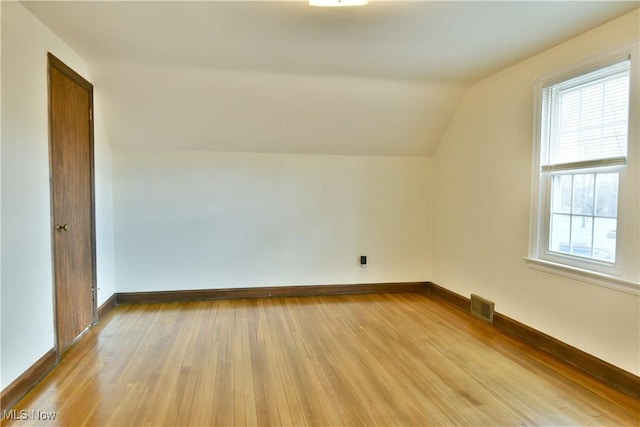 additional living space with a wealth of natural light, light hardwood / wood-style flooring, and vaulted ceiling