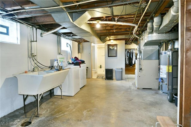 basement with heating unit, gas water heater, and independent washer and dryer