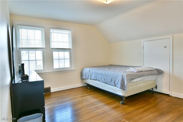 bedroom featuring wood-type flooring and lofted ceiling