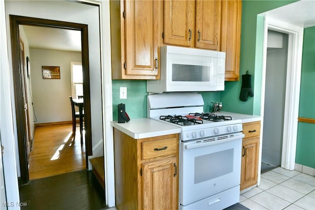 kitchen featuring light tile patterned floors and white appliances