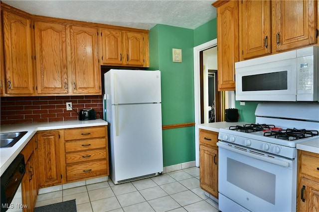 kitchen with light tile patterned flooring, white appliances, decorative backsplash, and a textured ceiling