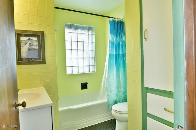 full bathroom with tile walls, tile patterned flooring, vanity, shower / tub combo, and toilet