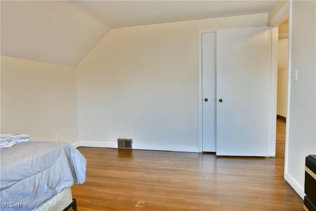 bedroom featuring hardwood / wood-style flooring and vaulted ceiling