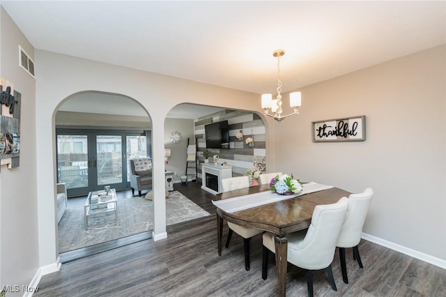 dining room featuring french doors, dark hardwood / wood-style flooring, and a chandelier