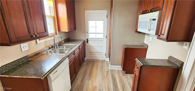 1151 Bedford Ave SW, Canton, OH 44710 - kitchen with white appliances, light wood-style flooring, dark countertops, a sink, and baseboards