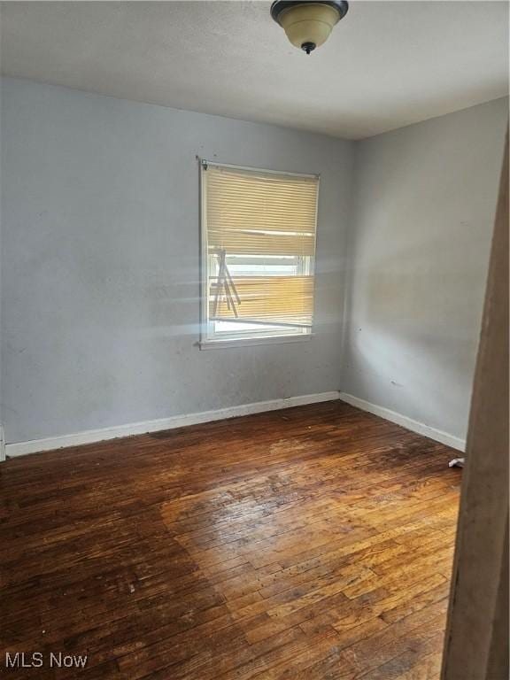 unfurnished room featuring dark hardwood / wood-style flooring