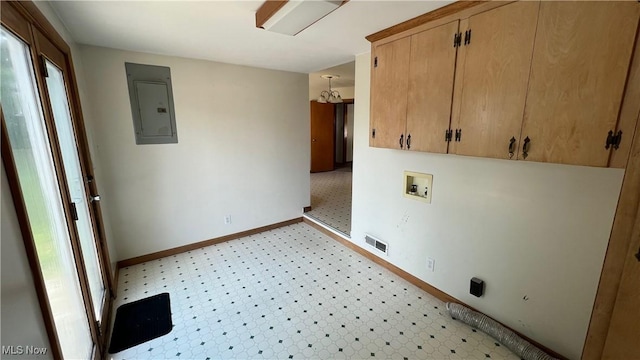 washroom featuring hookup for a washing machine, electric panel, and cabinets