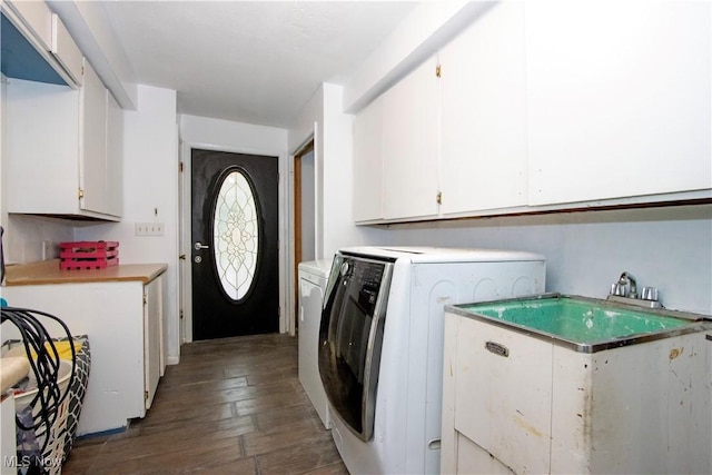 washroom with separate washer and dryer, sink, dark hardwood / wood-style floors, and cabinets