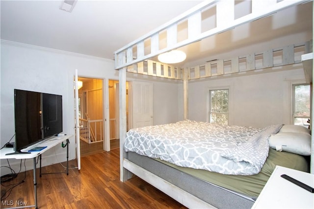 bedroom featuring crown molding and dark hardwood / wood-style flooring