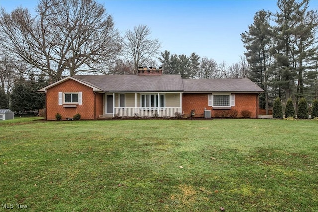 ranch-style home with a porch, a front yard, and central air condition unit