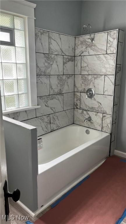 bathroom with tiled shower / bath combo and hardwood / wood-style flooring