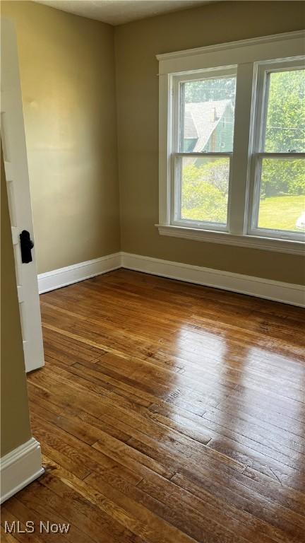 unfurnished room with dark hardwood / wood-style floors