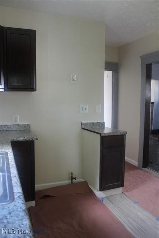 kitchen with light stone counters and light wood-type flooring