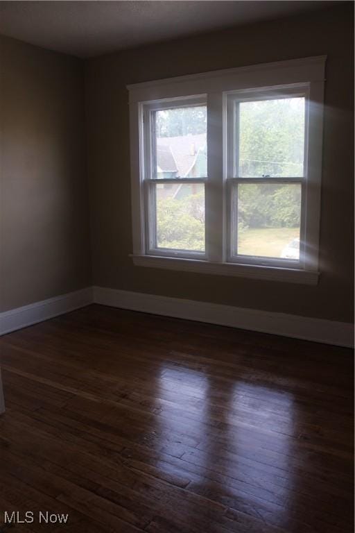 unfurnished room with dark hardwood / wood-style flooring