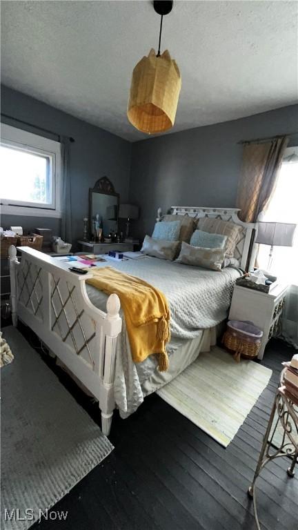 bedroom featuring dark wood-type flooring and a textured ceiling