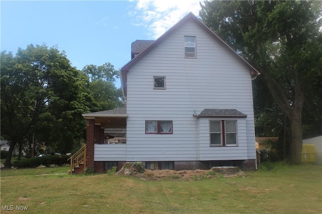 rear view of property featuring a lawn