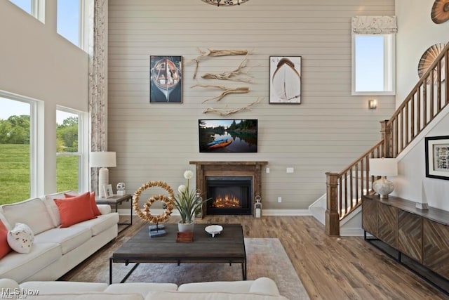 living room with a towering ceiling and hardwood / wood-style floors