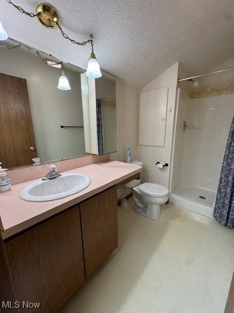 bathroom with toilet, a shower with curtain, vaulted ceiling, a textured ceiling, and vanity