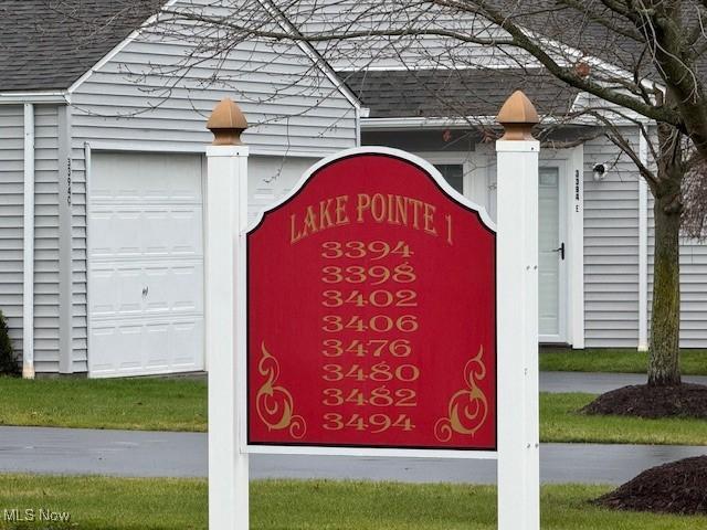 community / neighborhood sign featuring a garage