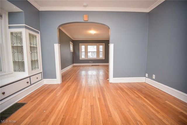 unfurnished room featuring crown molding and light wood-type flooring