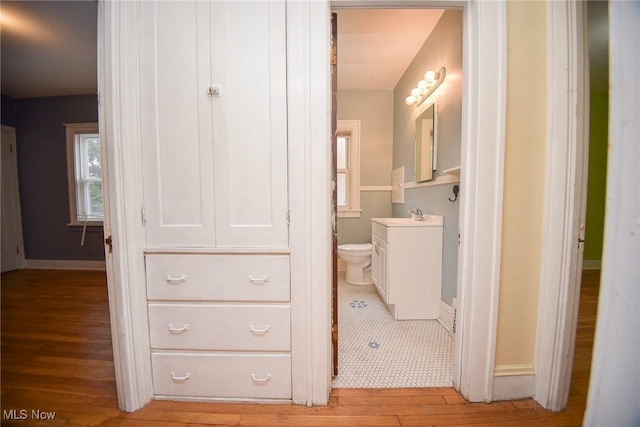 bathroom featuring hardwood / wood-style flooring, vanity, and toilet