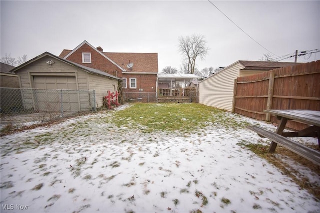 snowy yard featuring a garage