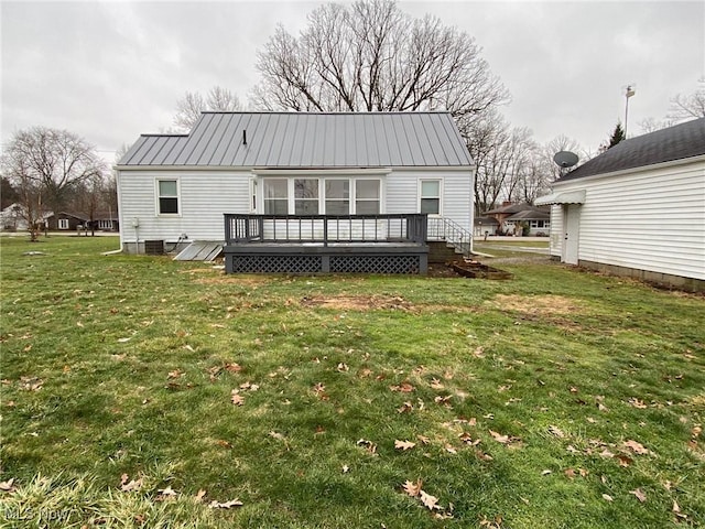 rear view of property featuring central air condition unit, a wooden deck, and a lawn