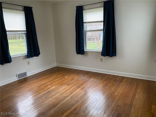 unfurnished room featuring hardwood / wood-style flooring and a healthy amount of sunlight