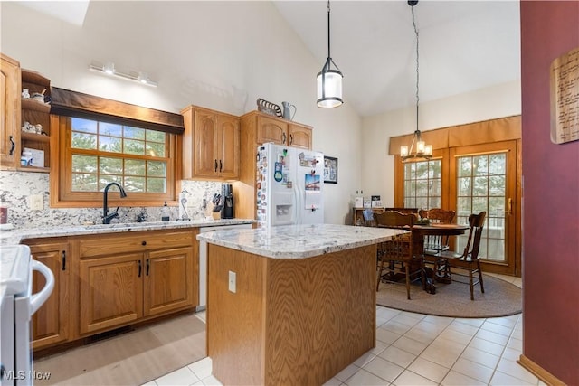 kitchen with hanging light fixtures, a center island, white fridge with ice dispenser, range, and light stone counters