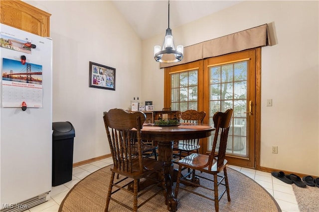 dining room with an inviting chandelier, lofted ceiling, and light tile patterned floors