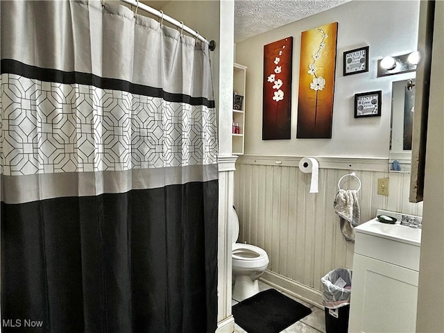 bathroom featuring tile patterned flooring, vanity, a textured ceiling, and toilet