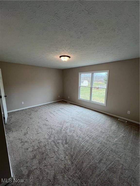 carpeted spare room with a textured ceiling