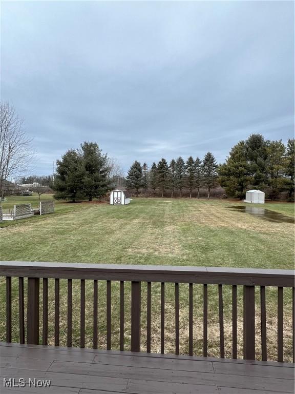 view of yard with a wooden deck and a shed