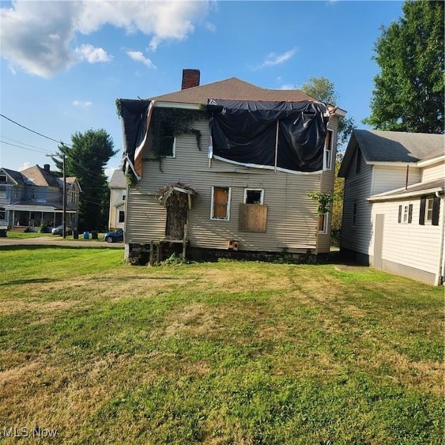 rear view of property with a yard