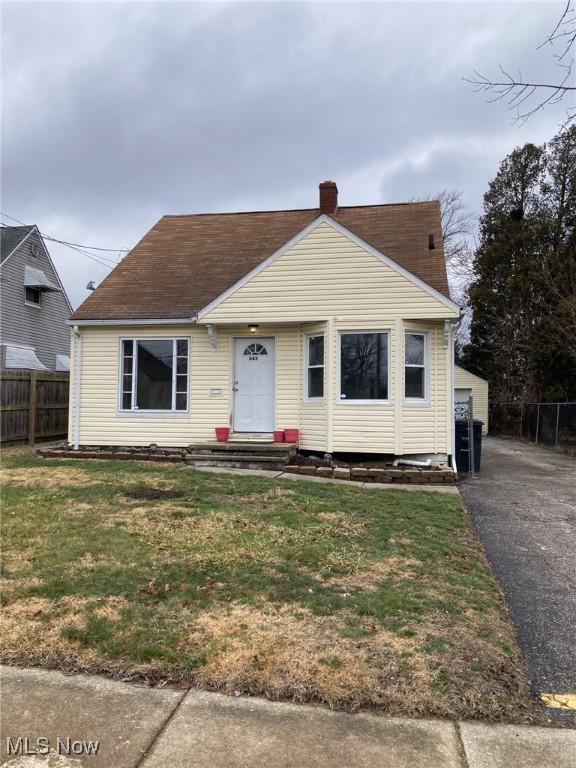 bungalow featuring an outbuilding, a garage, and a front yard