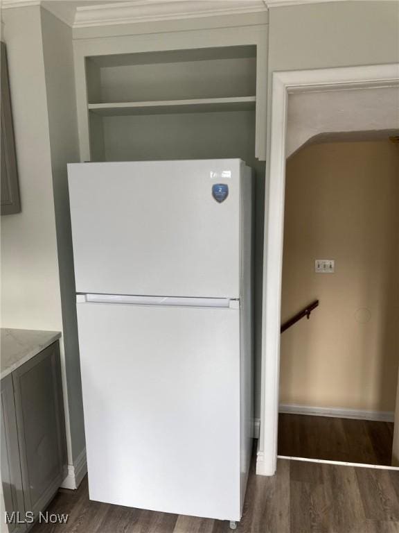 interior details with hardwood / wood-style flooring, crown molding, and white fridge