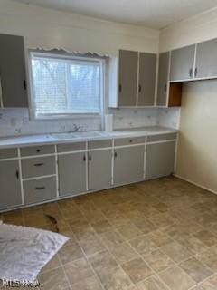 kitchen featuring sink and gray cabinetry