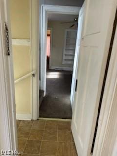 hallway featuring dark tile patterned flooring