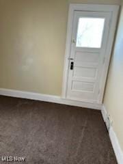 doorway to outside with dark carpet