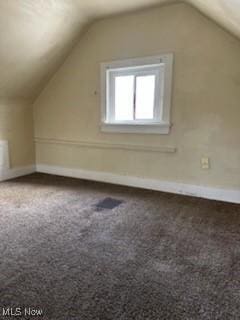 bonus room with lofted ceiling and carpet flooring