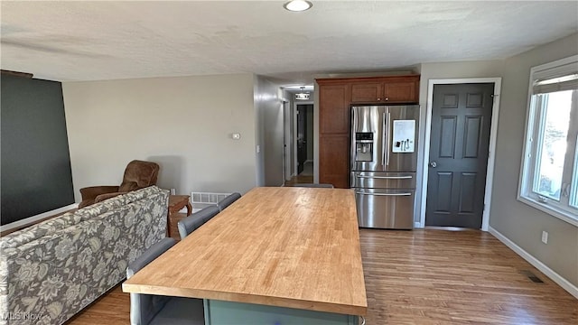 kitchen with dark wood-type flooring and stainless steel fridge with ice dispenser