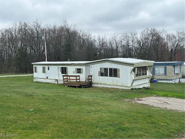 view of front of house with a wooden deck and a front yard