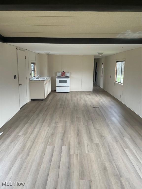 unfurnished living room with sink and light wood-type flooring