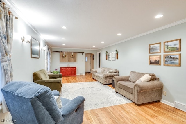 living room with ornamental molding and light hardwood / wood-style floors