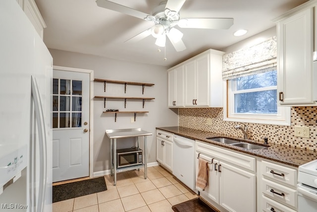 kitchen featuring white cabinetry, sink, dark stone countertops, and white appliances