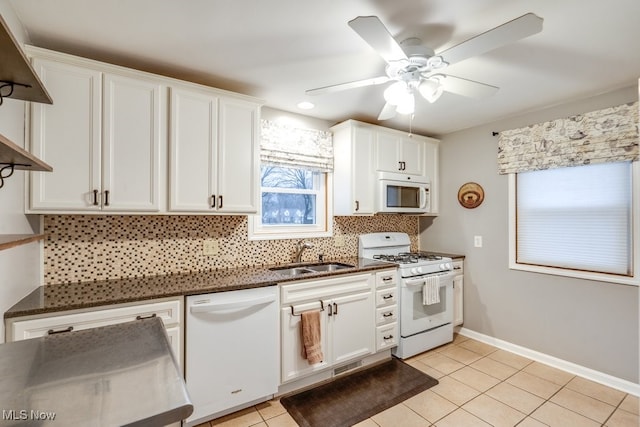 kitchen featuring sink, backsplash, white cabinets, light tile patterned floors, and white appliances