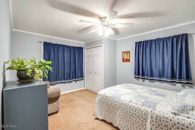 carpeted bedroom with ornamental molding, a closet, and ceiling fan